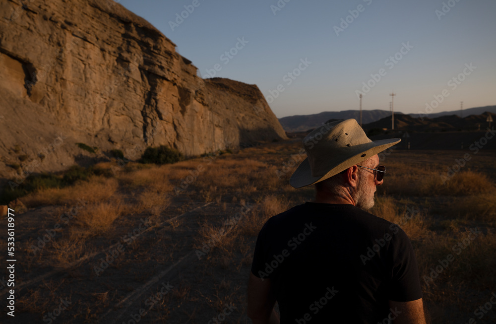 Adult man in cowboy hat and sunglasses in desert. Almeria, Spain Adult man in cowboy hat and sunglasses in desert. Almeria, Spain