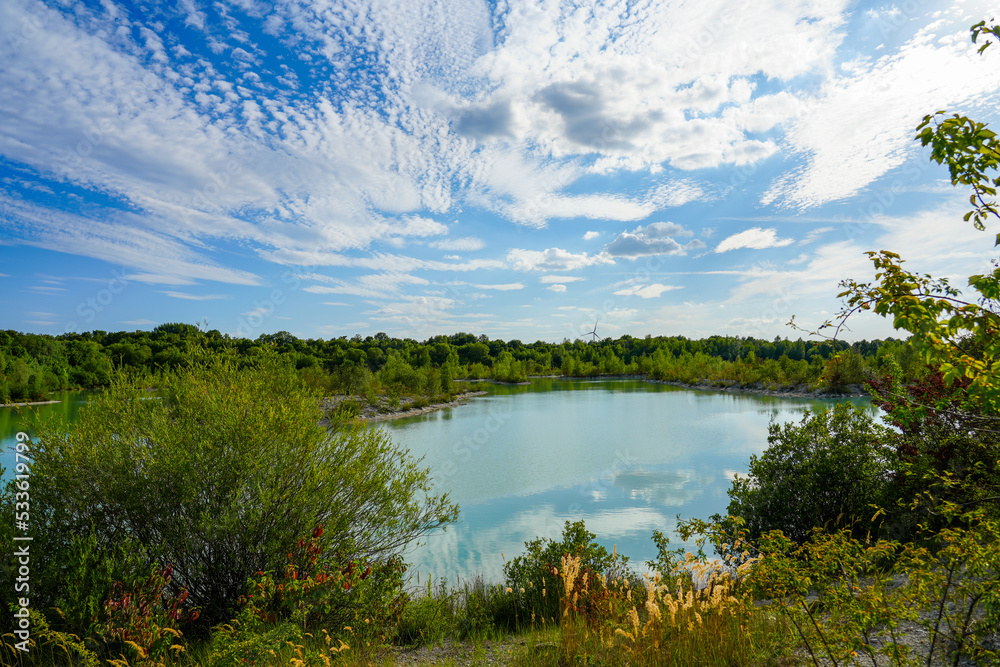 View of the Dyckerhoff lake in Beckum. Quarry west. Blue Lagoon. Landscape with a turquoise blue lake and the surrounding nature.
View of the Dyckerhoff lake in Beckum. Quarry west. Blue Lagoon. Landscape with a turquoise blue lake and the surrounding nature.