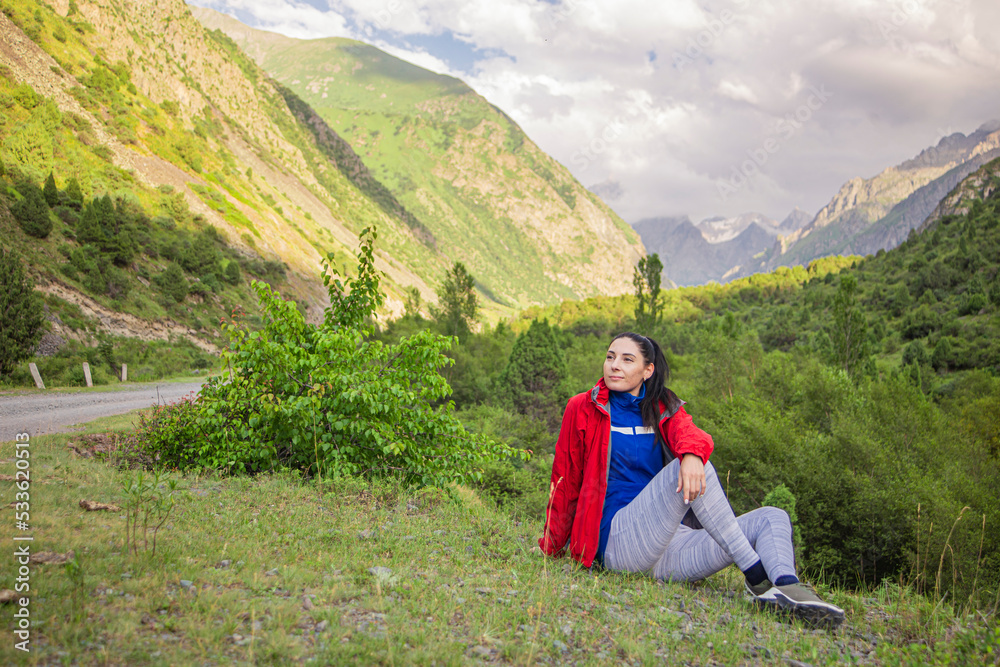 happy romantic girl sitting in the mountains enjoying fresh mountain air and birds singing