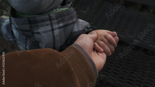 Close-up of a father giving his hand to his son. A young child holds his father's hand. . High quality 4k footage