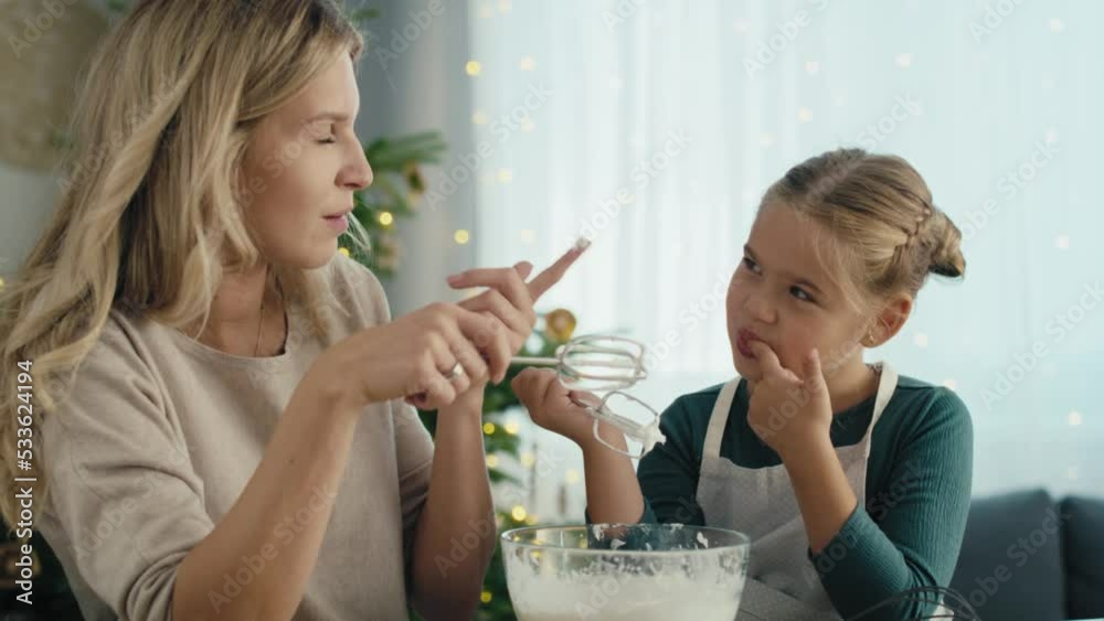 Caucasian mother and daughter preparing baking using electric mixer and later tasting. Shot with RED helium camera in 8K.   