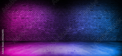 Black brick wall background with neon lighting effect from pink and purple to blue. Glowing lights in the dark on empty brick wall background