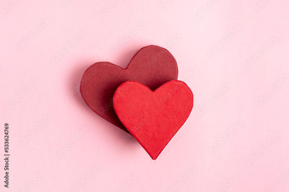 Beautiful closeup of red heart boxes on pink background. Shape background.Holiday background. Creative design. Red heart box present 