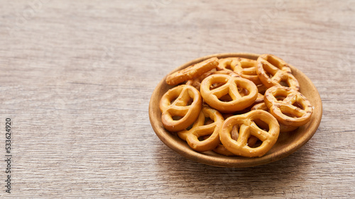 mini salted pretzel in a wooden plate on wood table background.                                           