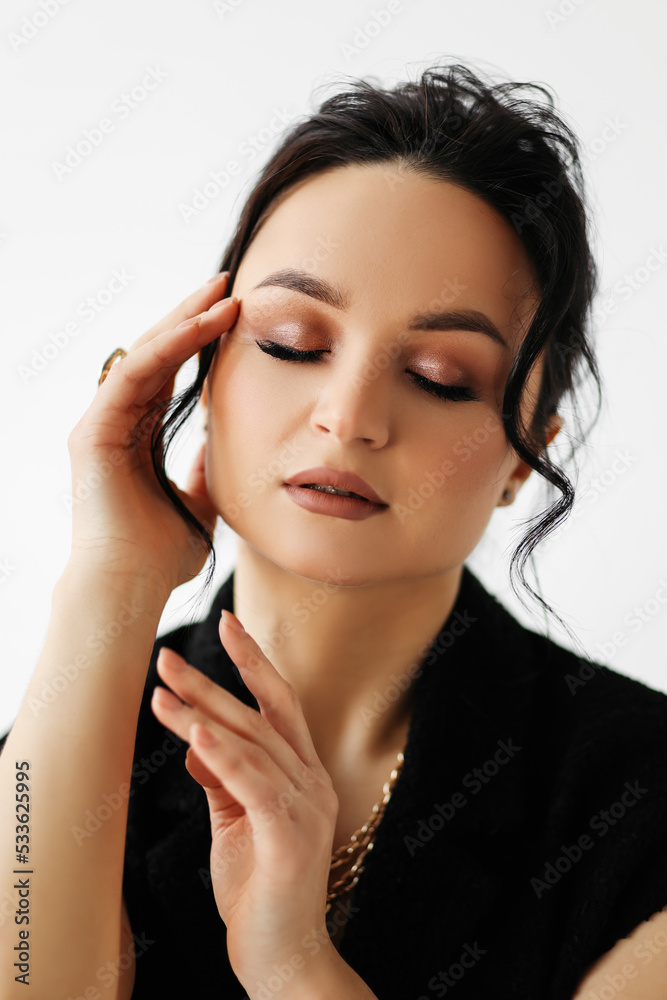 Beauty portrait of a beautiful young brunette woman with makeup and closed eyes. Attractive face of a fashionable and stylish girl on a white isolated background Beauty portrait of a beautiful young brunette woman with makeup and closed eyes. Attractive face of a fashionable and stylish girl on a white isolated background