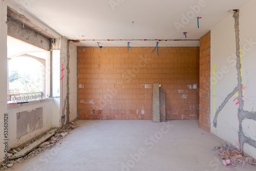 Large bright room with windows of an ancient villa undergoing renovation. The old walls have been torn down and new ones have been created