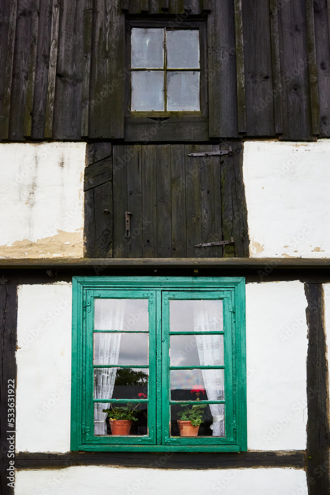 Small windows on a whitewashed wall with wooden beams Small windows on a whitewashed wall with wooden beams