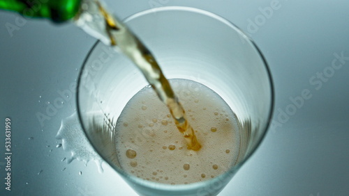 Glass lager beer pouring super slow motion. Fizzy alcoholic drink filling glass