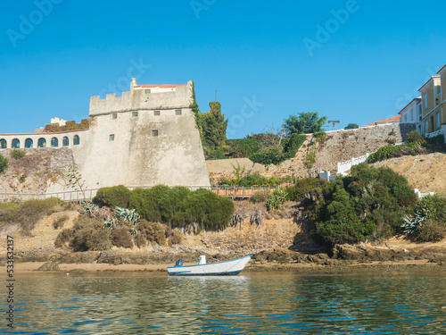 View of medieval fort Forte de Sao Clemente over the Mira river with small boat in sunny day with clear blue sky. Vila Nova de Milfontes, Portugal, Rota Vicentina coast photo