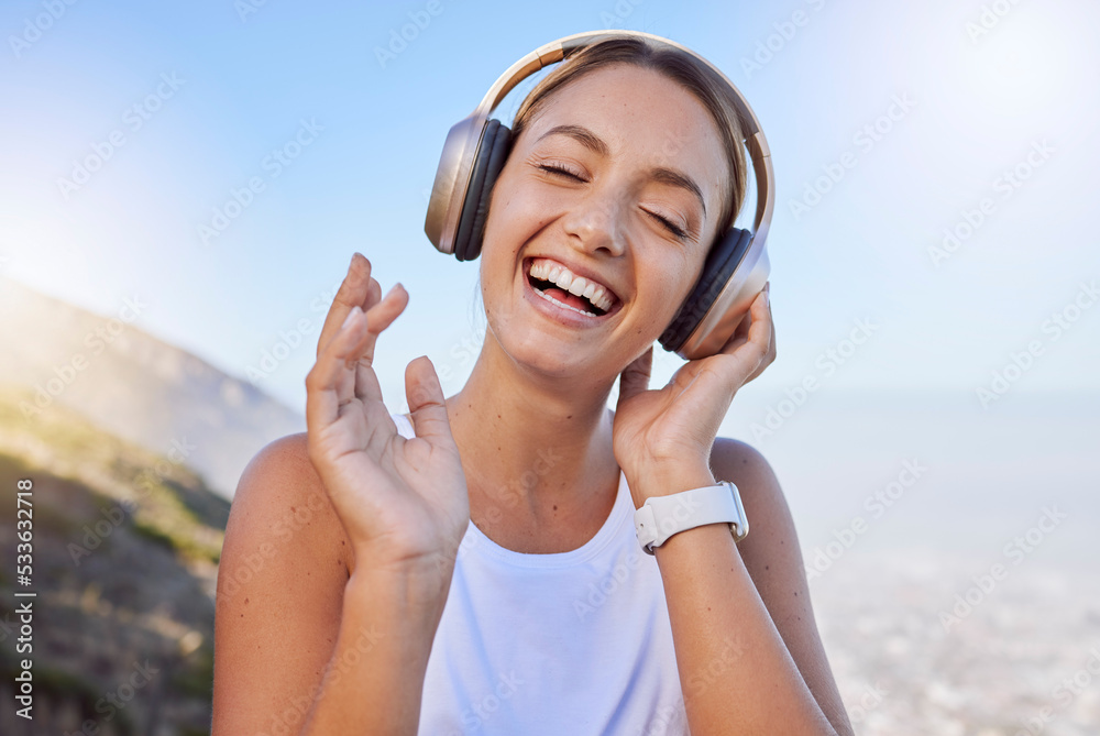 Smile, laughing and hiking woman with headphones in fun exercise, fitness  or workout in countryside mountains. Happy, face and comic athlete  listening to music, radio or funny audio podcast in nature Stock