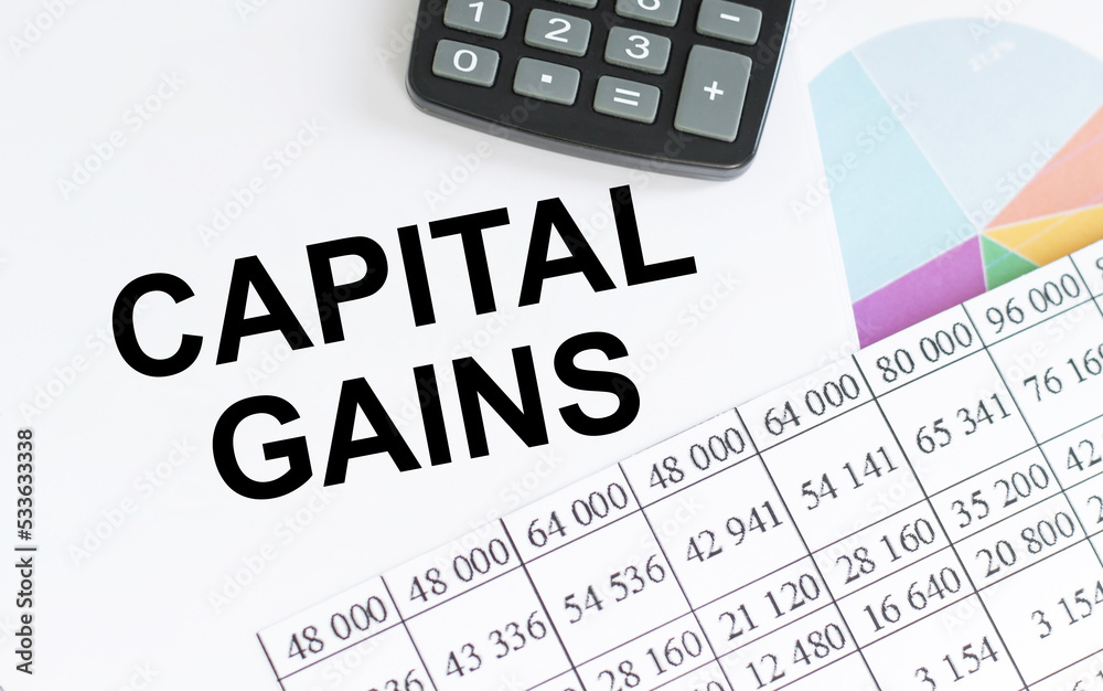 Financial concept. Text Capital Gains on a notebook among the documents on the table Financial concept. Text Capital Gains on a notebook among the documents on the table