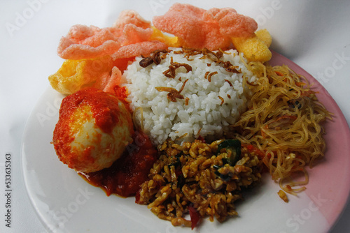 Nasi Uduk is a typical Jakarta Betawi dish, containing rice in coconut milk, vermicelli, eggs, kerupuk, tempe orek, and sambal photo