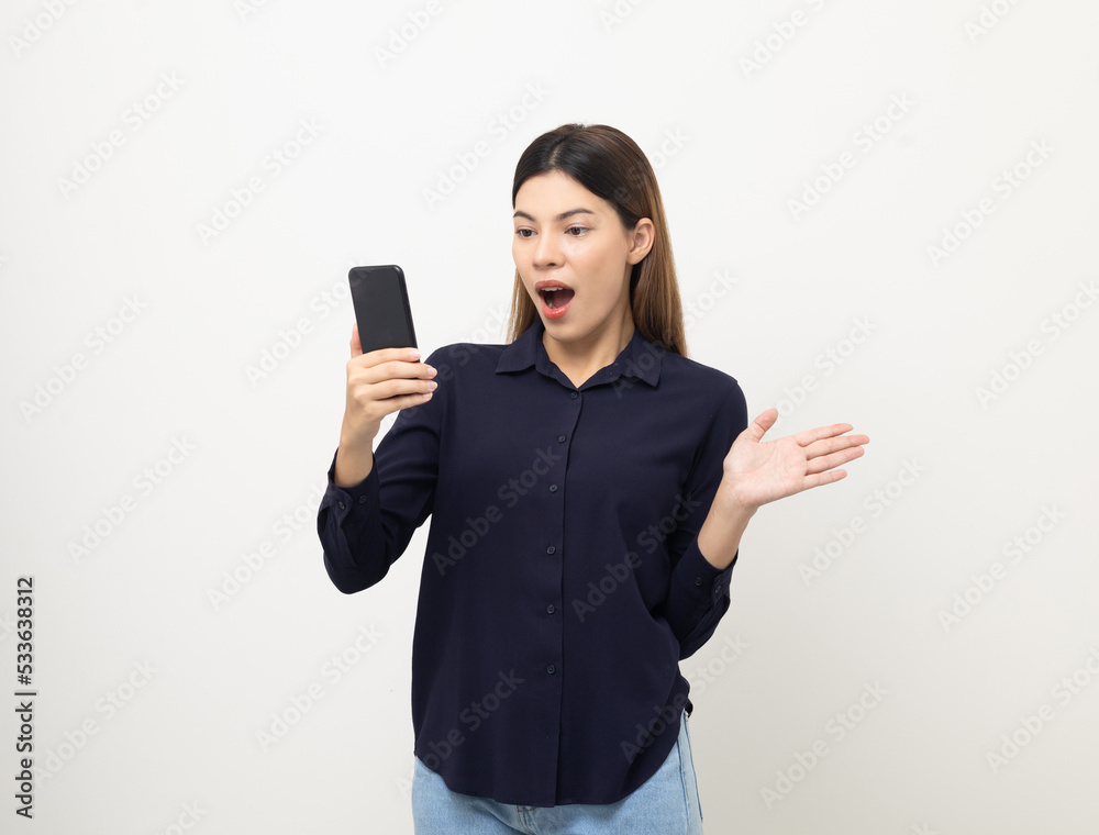 Pretty young mixed race woman using smartphone standing on isolated white background. She texting on cell phone. Feeling happy and excited