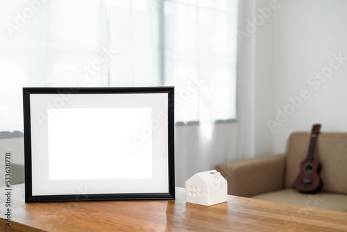 Style picture frame still life put on the wooden table in living room. Blank space empty picture frame with mockup. Natural light Template background interior design and decoration © Chanakon