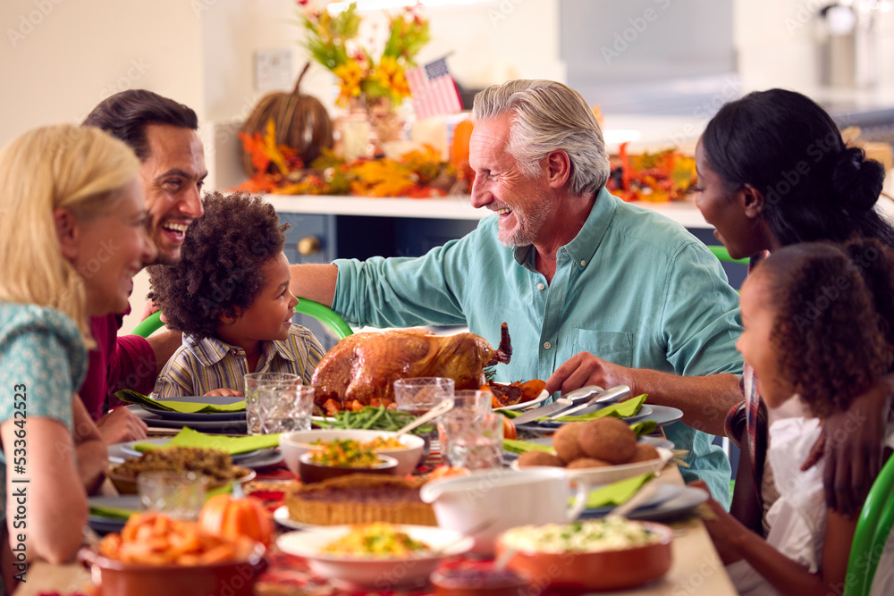 Multi-Generation Family Celebrating Thanksgiving At Home Eating Meal Together