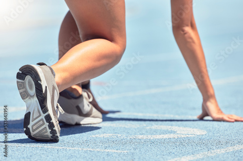 Running, shoes and start with a sports woman or female runner on a track for a workout, exercise or training. Fitness, run and cardio with an athlete getting ready for a competition or race outside