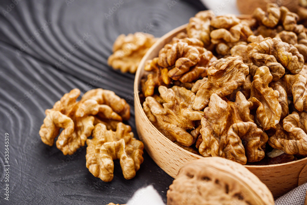 dried walnuts on a black rustic wooden background dried walnuts on a black rustic wooden background