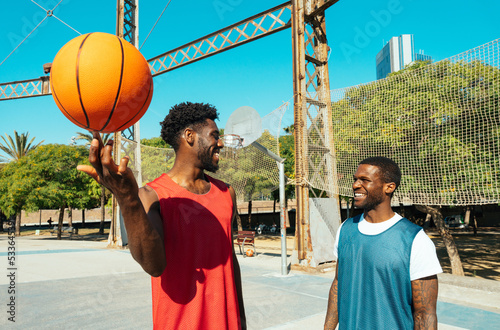 One vs one basketball game training at the court. Cinematic look image of friends practicing shots and slam dunks in an urban area