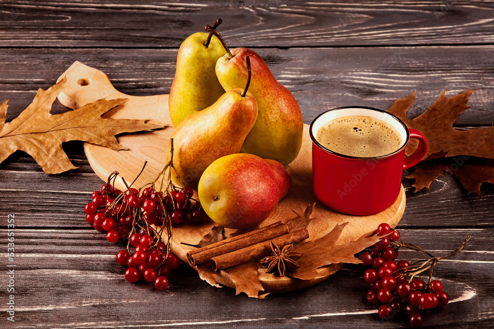 Yellow-red ripe pears and a red cup of coffee on a wooden board on a dark background. Autumn composition of fruits with autumn leaves, viburnum, with spices, cinnamon and anise. Yellow-red ripe pears and a red cup of coffee on a wooden board on a dark background. Autumn composition of fruits with autumn leaves, viburnum, with spices, cinnamon and anise.