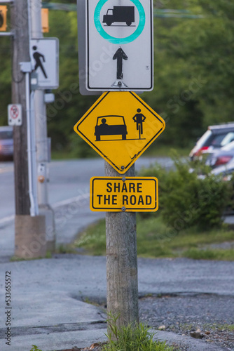 SHARE THE ROAD a road sign with a bicycle symbol informational for the traffic. Yellow Diamond Warning Sign