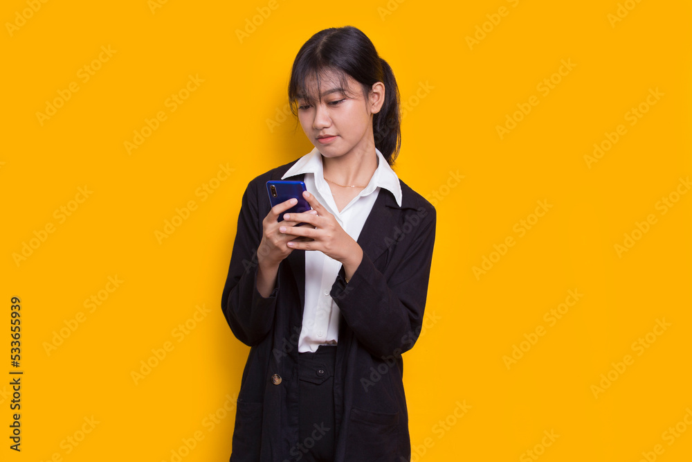 happy young asian business woman using mobile phone isolated on yellow background
happy young asian business woman using mobile phone isolated on yellow background