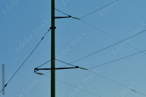 Concrete support for high-voltage wires, horizontal crossbars with wires on a clear sky background, abstract geometric lines, still life of their electrical equipment