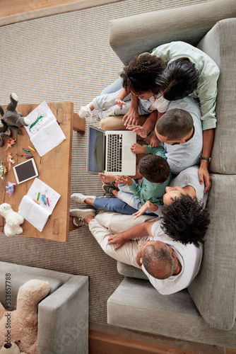 Family, children and video call with kids, parents and grandparents using a laptop on the sofa at home. Communication, wave and internet with a girl, boy and relatives in a living room from above