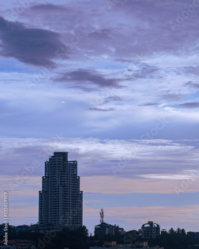 A picture of a sky scraper and a beautiful red and purple sky during the dusk 