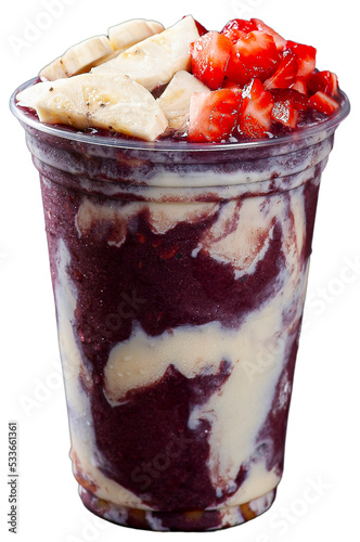 Brazilian frozen açaí in a plastic cup with condensed milk and strawberry. Fruit from the Amazon.