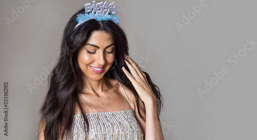 Beautiful smiling woman with Birthday Girl Tiara and shiny dress holding party balloons . Birthday party concept