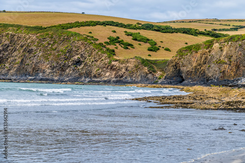 A view past  rock pools on the beach at low tide at Newport, Pembrokeshire, Wales on a summers day photo