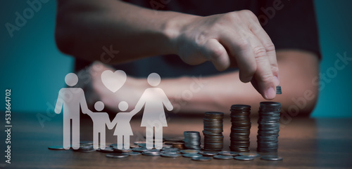 Businessman take a coin money into stack with paper family beside for education, donation, saving, charity, family finance plan concept, fundraising, superannuation, financial crisis concept.