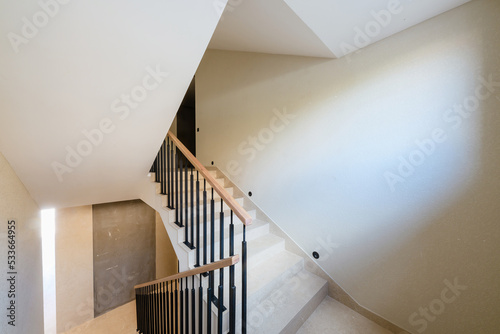 new stylish tile stairs with black metal railings in the house