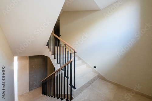 new stylish tile stairs with black metal railings in the house