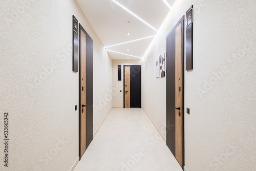 a bright corridor with dark doors and bright lighting. New house
