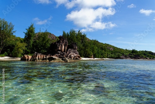 Beach on Curieuse Island, Seychelles, with lava stone rocks and lush vegeration photo