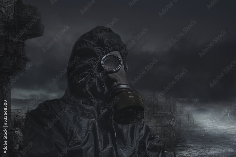 A man in a gas mask and a chemical protection suit. Man against the dark backdrop of a post-apocalyptic landscape.