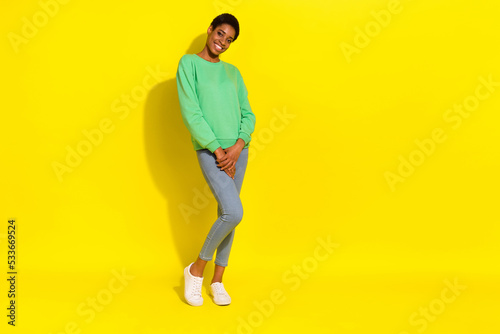 Full length body size view of attractive cheerful girl posing copy space isolated over vivid yellow color background