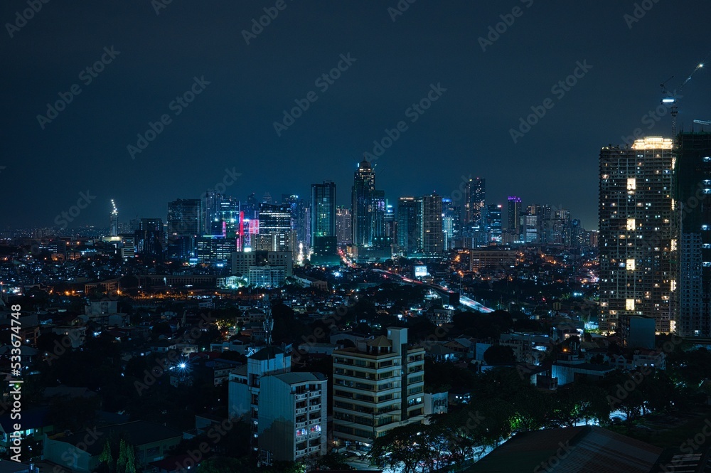 Night city view of business district with skyscrapers in Manila, Philippines
