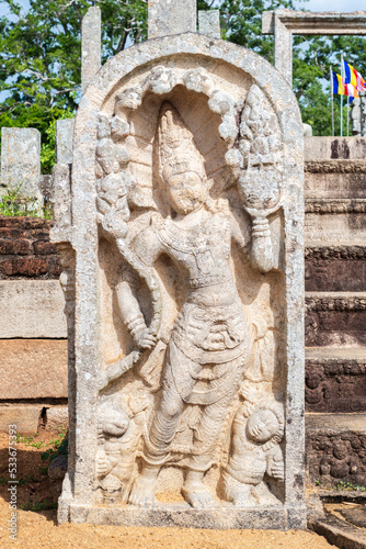 Guard stone in Thuparama temple entrance, naga raja and two dwarfs carved in one stone. photo