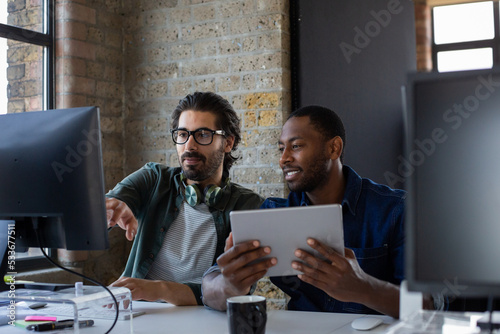 Coworkers working together on a desktop computer photo