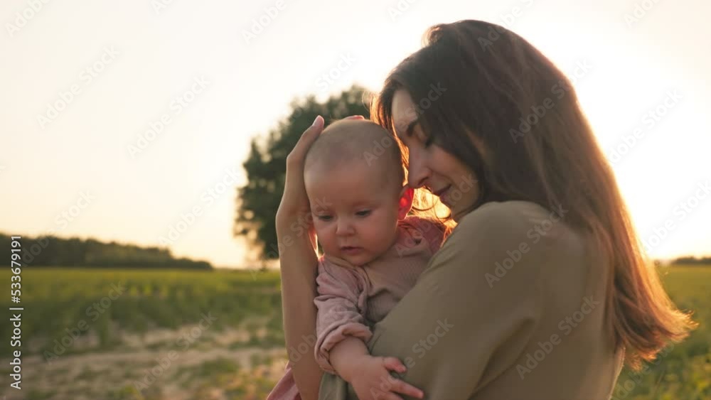 Little daughter sitting in mothers hands. Happy child and proud mom are playing in field of sunflower. Happy family concept. Little daughter sitting in mothers hands. Happy child and proud mom are playing in field of sunflower. Happy family concept.