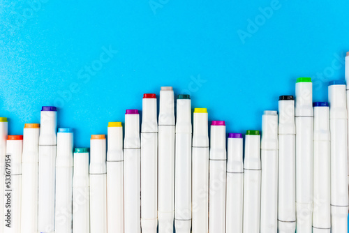 Many colorful white markers lie on a blue background.