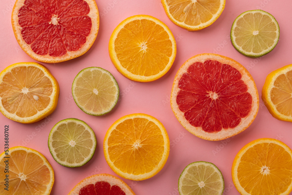 Slices of tropical fruits on a pink background. Top view.