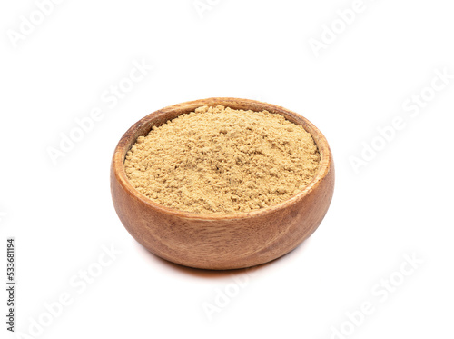 Wooden bowl with ground ginger root powder over white background.