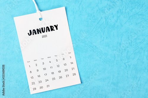 The 2023 January calendar page hanged on white rope  on blue background.