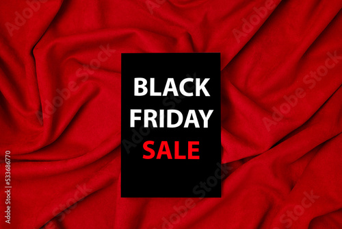 Black Friday tag on red fabric background.Sale promotion poster. Discount, sale season.