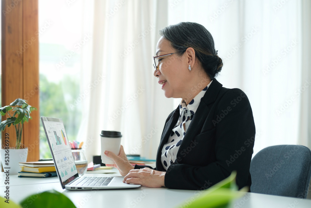 Senior Asian woman working from home with laptop and smart phone. Old woman living and learning online. Senior Asian woman working from home with laptop and smart phone. Old woman living and learning online.