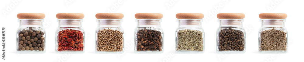 Set of glass jars with different spices on a white isolated background Set of glass jars with different spices on a white isolated background