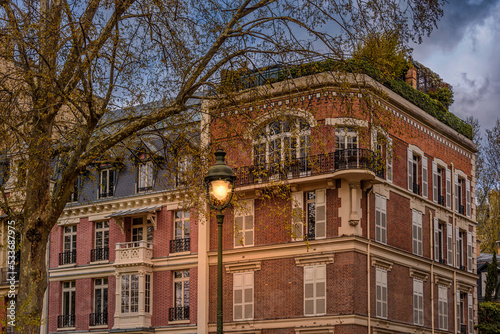 Fototapeta Naklejka Na Ścianę i Meble -  Traditional Parisian house facades at the light of a street lantern